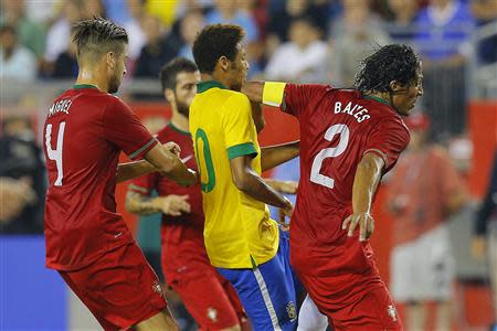 Brazil's Neymar (C) is hit by the elbow of Portugal's Bruno Alves (R) as Neymar attempts to go between Alves and Portugal's Miguel Veloso during their international friendly football match in Foxborough, Massachusetts September 10, 2013. REUTERS/Brian Snyder