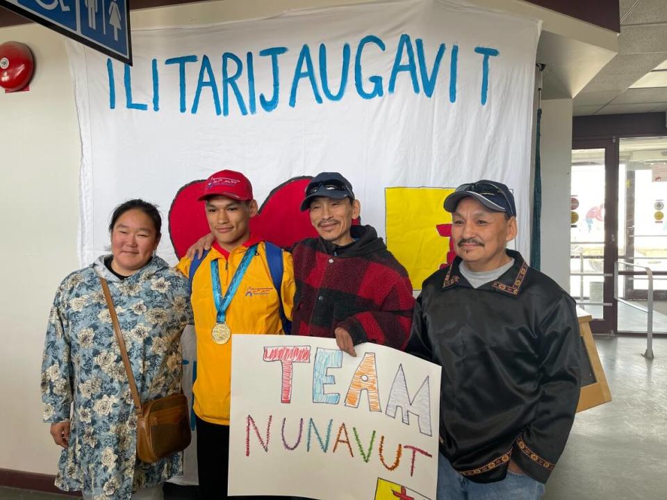 Supporters gather to pose with Nunavut wrestler Eekeeluak Avalak, second from left, who won gold at the 2022 Canada Sumer Games. (Juanita Taylor/CBC - image credit)