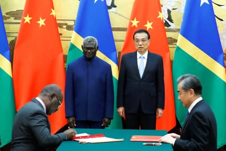 Solomon Islands Prime Minister Manasseh Sogavare, Solomon Islands Foreign Minister Jeremiah Manele, Chinese Premier Li Keqiang and Chinese State Councillor and Foreign Minister Wang Yi attend a signing ceremony at the Great Hall of the People in Beijing