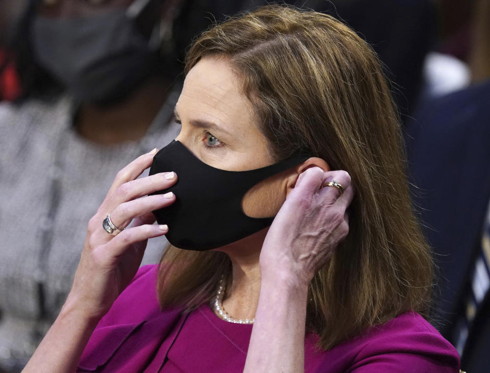 Supreme Court nominee Amy Coney Barrett puts her face mask back on after taking a drink during her Senate Judiciary Committee confirmation hearing on Capitol Hill in Washington, Monday, Oct. 12, 2020. (Kevin Dietsch/Pool via AP)