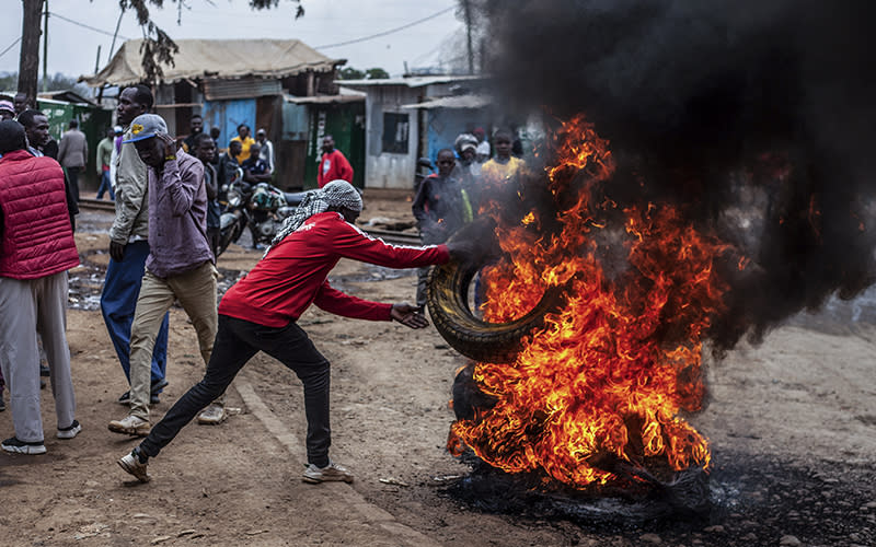 A protester burns tyres to block the road in the Kibera neighborhood of Nairobi, Kenya