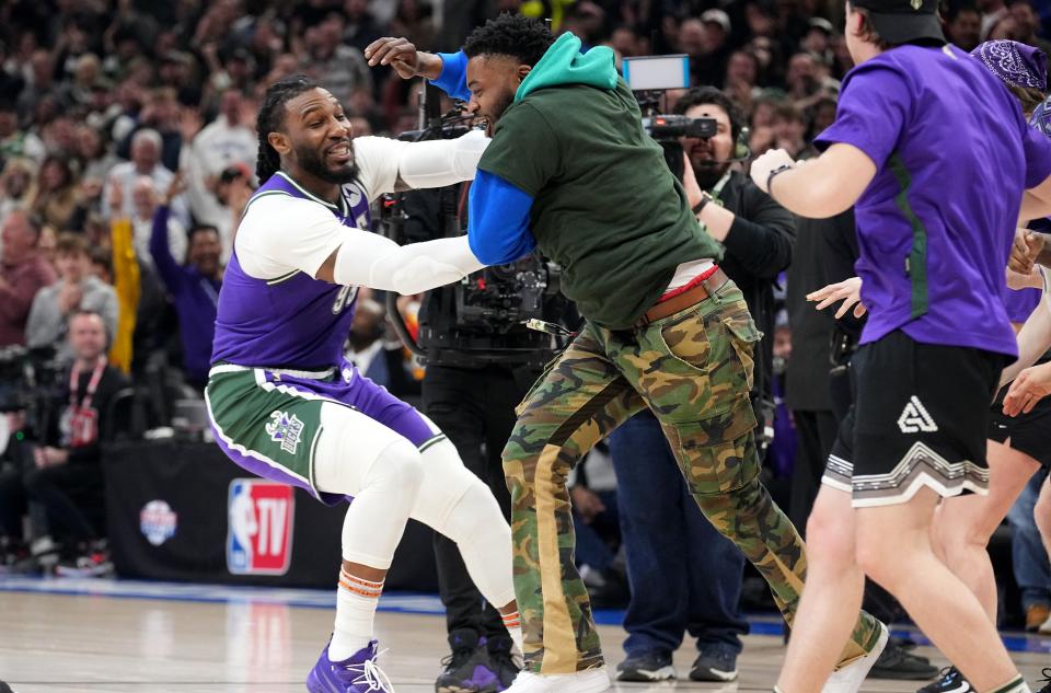 Milwaukee Bucks forward Jae Crowder (99) celebrates with a fan who hit a half court shot for $10,000 during the first half of their game against the Memphis Grizzlies Friday, April 7, 2023 at Fiserv Forum in Milwaukee, Wis.