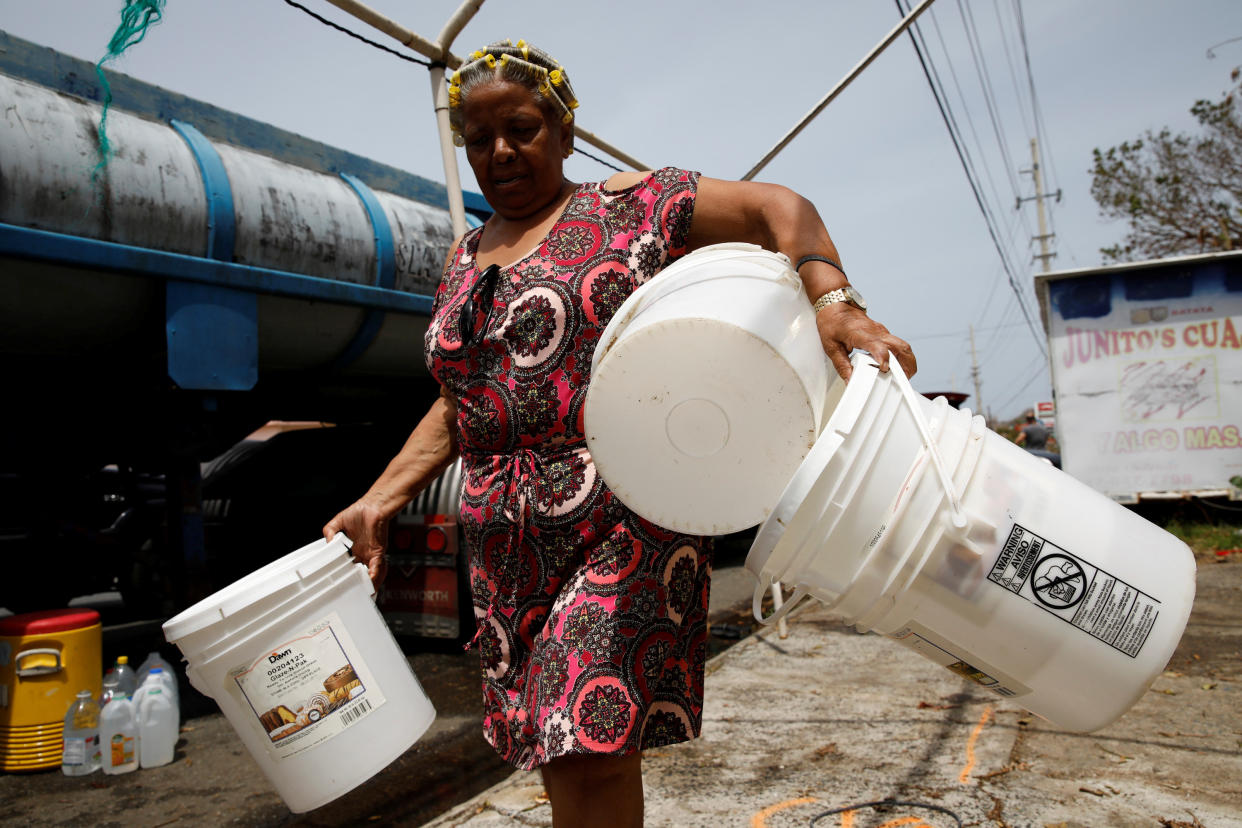 Post-Hurricane Maria, a woman carries buckets to be filled with water from a tank truck in Canovanas, Puerto Rico, on Sept. 26, 2017. (Photo: Carlos Garcia Rawlins / Reuters)