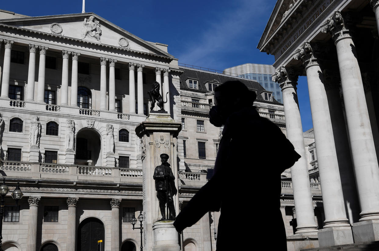 A person wearing a mask walks past the Bank of England, as the spread of the coronavirus disease (COVID-19) continues, in London, Britain, March 23, 2020. REUTERS/Toby Melville