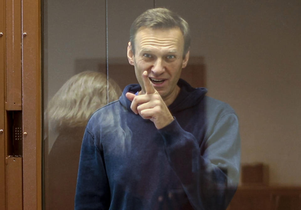 In this photo taken from a footage provided by the Babuskinsky District Court Tuesday, Feb. 16, 2021, Russian opposition leader Alexei Navalny gestures during a hearing on his charges for defamation in the Babuskinsky District Court in Moscow, Russia. Navalny is accused of defaming a World War II veteran who was featured in a video last year advertising constitutional amendments that allowed an extension of President Vladimir Putin's rule. (Babuskinsky District Court Press Service via AP)