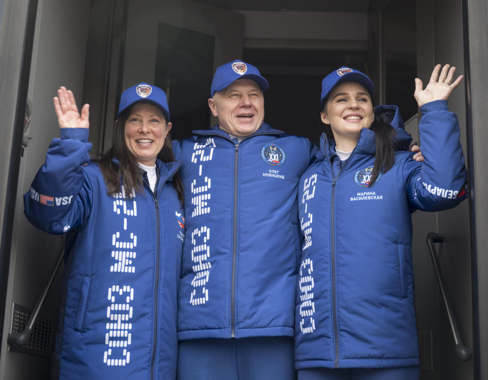 Expedition 71 NASA astronaut Tracy Dyson, left, Roscosmos cosmonaut Oleg Novitskiy, and Belarus spaceflight participant Marina Vasilevskaya, right, wave as they depart the Cosmonaut Hotel to suit-up for their Soyuz launch to the International Space Station, Thursday, March 21, 2024, in Baikonur, Kazakhstan.(Bill Ingalls/NASA via AP)