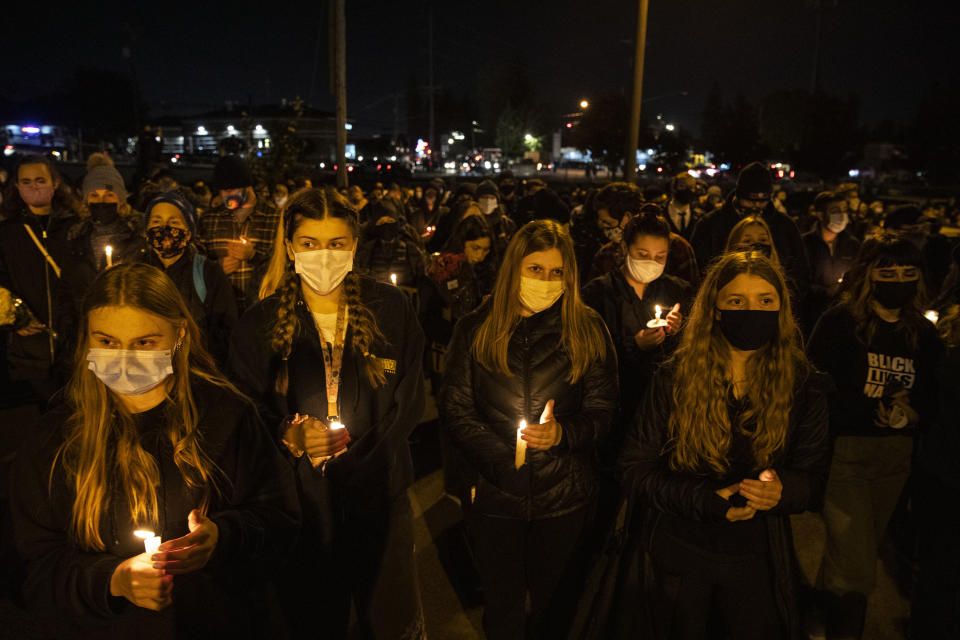 People gather for Kevin Peterson Jr., who was killed in Thursday's shooting with police involved, at a candlelight vigil in Vancouver, Wash., Friday, Oct. 30, 2020. The Clark County Sheriff's office has not released any details on the Thursday evening shooting in Hazel Dell, but a man told The Oregonian/OregonLive that his 21-year-old son was fatally shot by police. (AP Photo/Paula Bronstein)