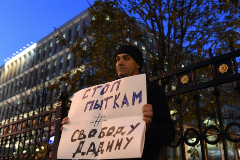 A man holds a placard reading "Stop torture, Freedom for Dadin" as he pickets Russia's Federal Penitentiary Service headquarters in Moscow