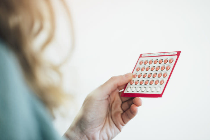 A person holding birth control pills