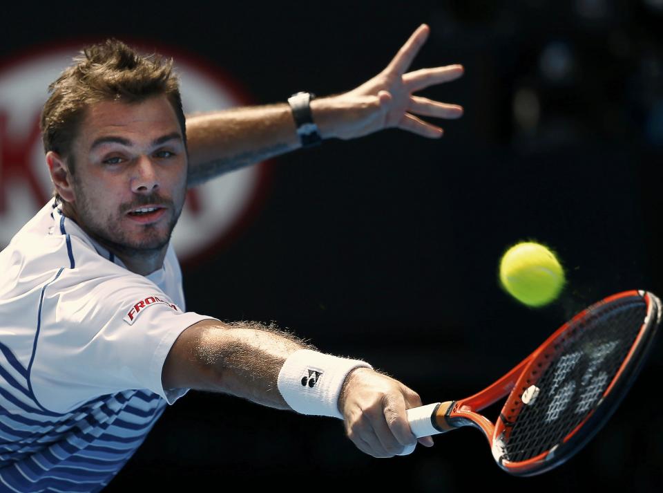 Stan Wawrinka of Switzerland stretches to hit a return to Kei Nishikori of Japan during their men's singles quarter-final match at the Australian Open 2015 tennis tournament in Melbourne January 28, 2015. REUTERS/Issei Kato (AUSTRALIA - Tags: SPORT TENNIS)