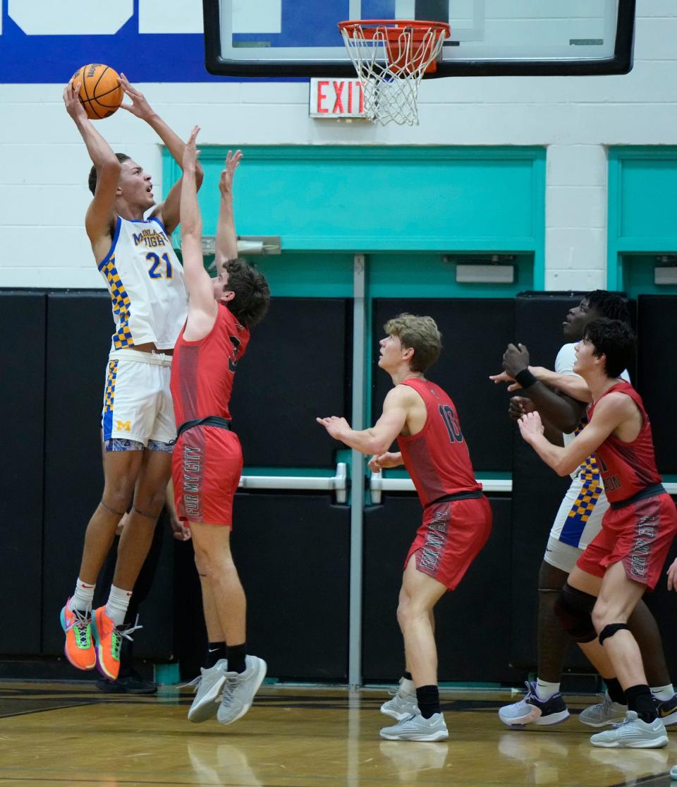 Mainland's DeAndre Newland (21) attempts to shoot over New Smyrna Beach's Michael Goldner (3) during the Five Star Conference Tournament finals at Atlantic High School in Port Orange, Friday, Jan. 26, 2024.