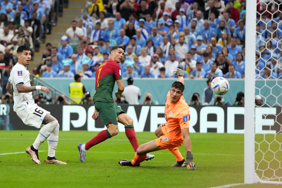 Portugal's Cristiano Ronaldo, center, scores the opening goal during the World Cup group H soccer match between Portugal and Uruguay, at the Lusail Stadium in Lusail, Qatar, Monday, Nov. 28, 2022. (AP Photo/Petr David Josek)