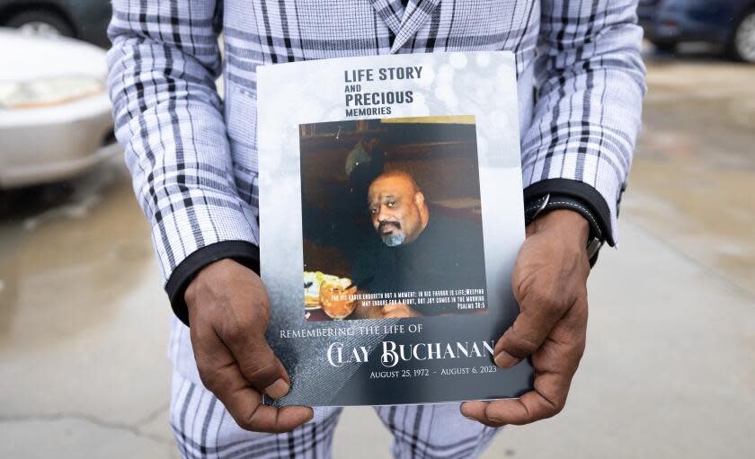 LOS ANGELES, CA - SEPTEMBER 02: Christopher C. Buchanan holds a funeral service program for his older brother Clay Buchanan at True Everfaithful Baptist Church in Los Angeles, CA on Saturday, Sept. 2, 2023. Clay Buchanan, 50, was killed in August when someone set his vehicle on fire while he slept in South L.A. (Myung J. Chun / Los Angeles Times)