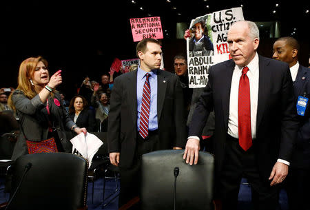 Protesters disrupt proceedings as Deputy National Security Adviser John Brennan (R) arrives to testify before a Senate Intelligence Committee hearing on his nomination to be the director of the CIA, on Capitol Hill in Washington, DC, U.S. on February 7, 2013. REUTERS/Jason Reed/File Photo