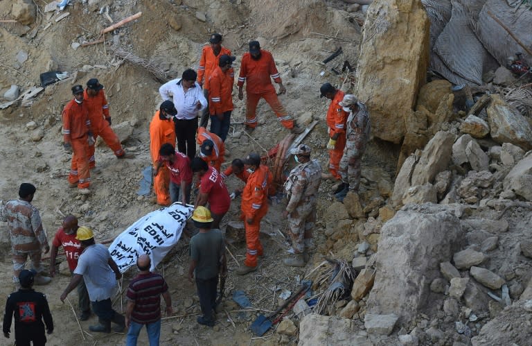 Rescuers carry the body of a victim of a landslide in Karachi, on October 13, 2015