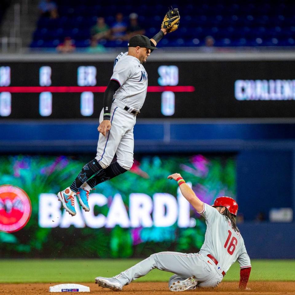 El torpedero de los Marlins Miguel Rojas salta para atrapar la pelota en una jugada en segunda base con Brandon Marsh, de los Flis de Filadelfia, en el tercer inning del partido celebrado el 13 de septiembre de 2022 en Miami.