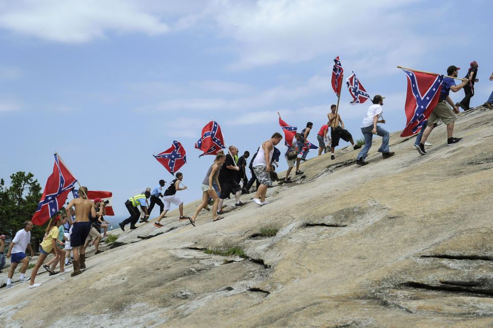 FILE - In this Aug. 1, 2015 file photo, supporters carrying Confederate battle flags climb Stone Mountain to protest what they believe is an attack on their Southern heritage during a rally in Stone Mountain, Ga. The battle flag, with its red background and blue X design, is the best known of the flags of the Confederacy, but the nation also used other banners. (AP Photo/John Amis, File)