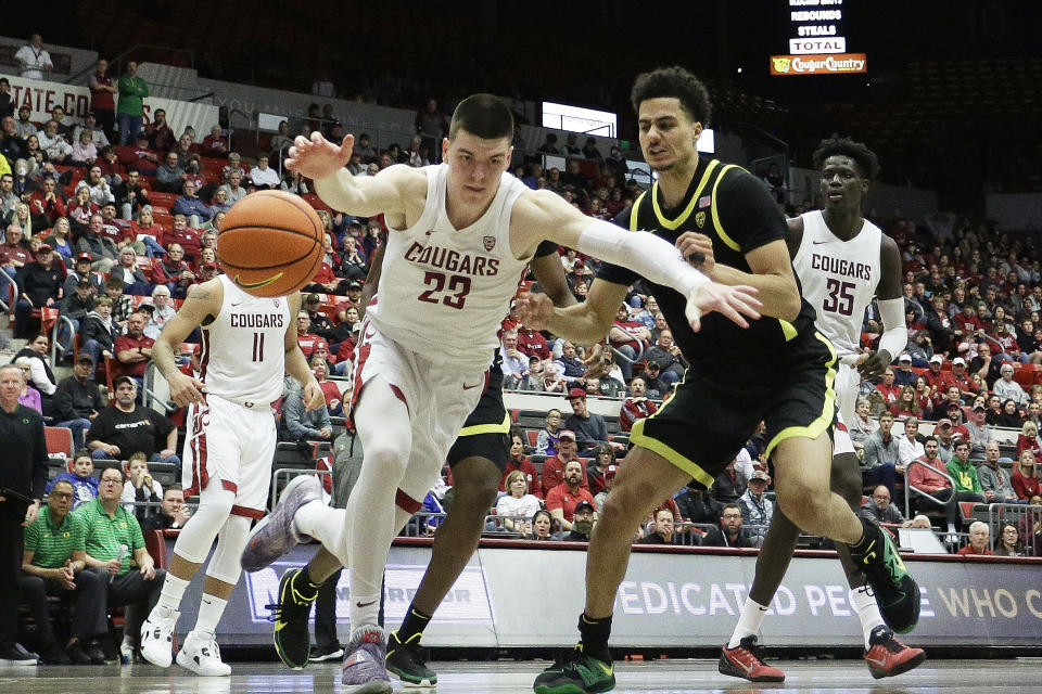 Washington State forward Andrej Jakimovski (23) and Oregon guard Will Richardson go after the ball during the second half of an NCAA college basketball game, Sunday, Feb. 19, 2023, in Pullman, Wash. Washington State won 68-65. (AP Photo/Young Kwak)