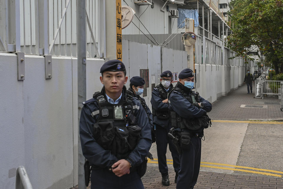 Police officers stand watch outside the West Kowloon Magistrates' Courts, where activist publisher Jimmy Lai's trial takes place, in Hong Kong, Tuesday, Jan. 2, 2024. (AP Photo/Billy H.C. Kwok)