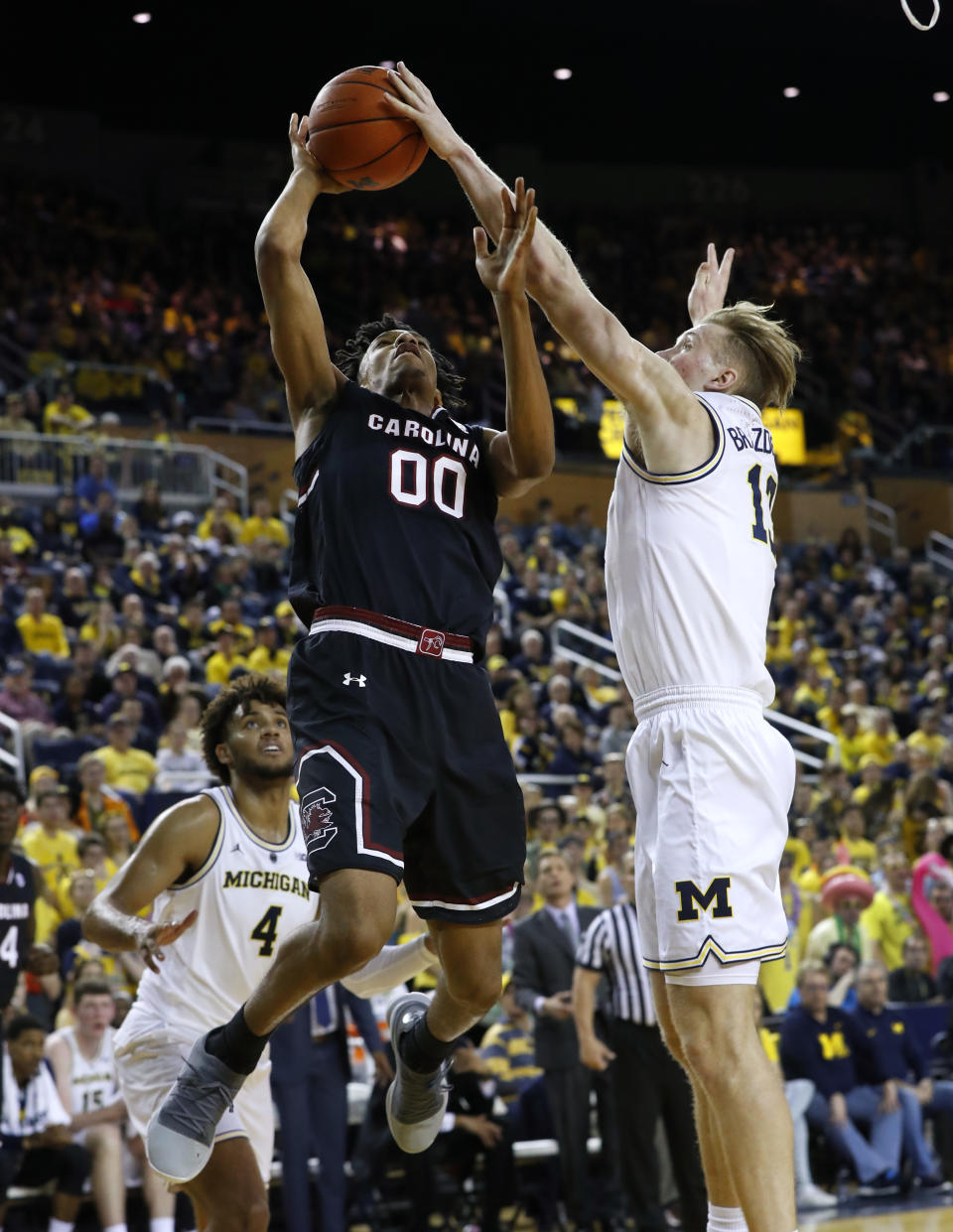 Michigan forward Ignas Brazdeikis (13) blocks shot by South Carolina guard A.J. Lawson (00) during the first half of an NCAA college basketball game in Ann Arbor, Mich., Saturday, Dec. 8, 2018. (AP Photo/Paul Sancya)