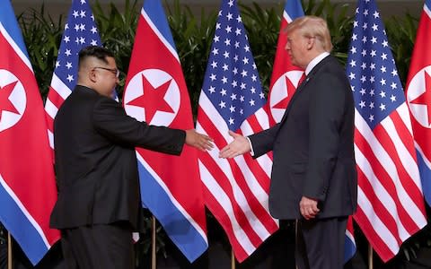 Donald Trump prepares to shake hands with Kim Jong-un - Credit: Reuters