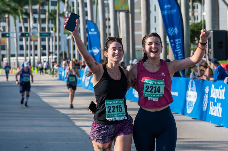 Marathon runners Kylie Pope, Pahokee, and Sara Lezcano, West Palm Beach, cross the finish line on South Flagler Drive during the Garden of Life Palm Beaches Marathon on Sunday, December 11, 2022, in downtown West Palm Beach, FL. Thousands of runners participated in races held over the weekend, which ranged from a 5K all the way to a 26.2 mile-long marathon.