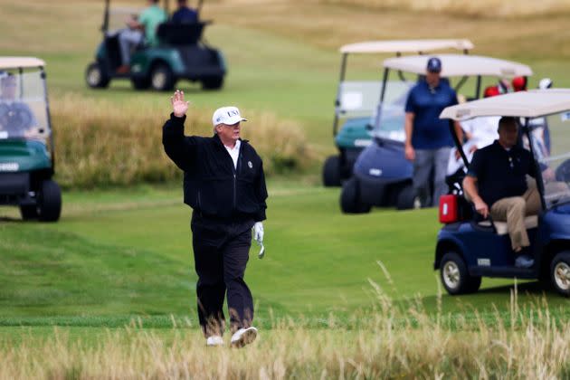 This July 14, 2018, file photo shows then-President Donald Trump waving to protesters while playing golf at his Turnberry golf club in Scotland. (Photo: via Associated Press)
