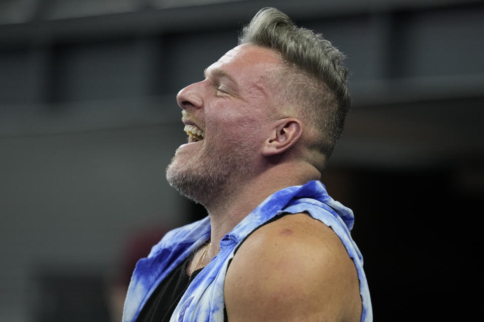 Sports analyst Pat McAfee smiles on the field before an NFL football game between the Indianapolis Colts and the Houston Texans, Saturday, Jan. 6, 2024, in Indianapolis. (AP Photo/Darron Cummings)