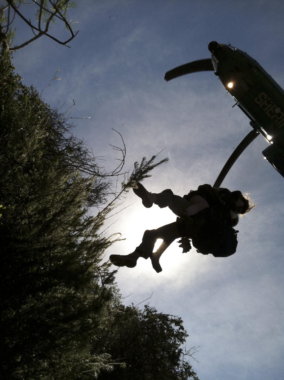 This photo provided by Los Angeles County Search and Rescue Reserve Deputy Doug Cramoline shows the helicopter rescue of Kyndall Jack, 18, by an L.A. County deputy after being missing for five days in rugged country near Rancho Santa Margarita, Calif., Thursday, April 4, 2013. A rescue team followed the sounds of a screaming female voice to an almost vertical canyon wall where they found Jack clinging to a rocky outcropping after going missing during a last Sunday. (AP Photo/L.A. County Search and Rescue Reserve, Deputy Doug Cramoline)