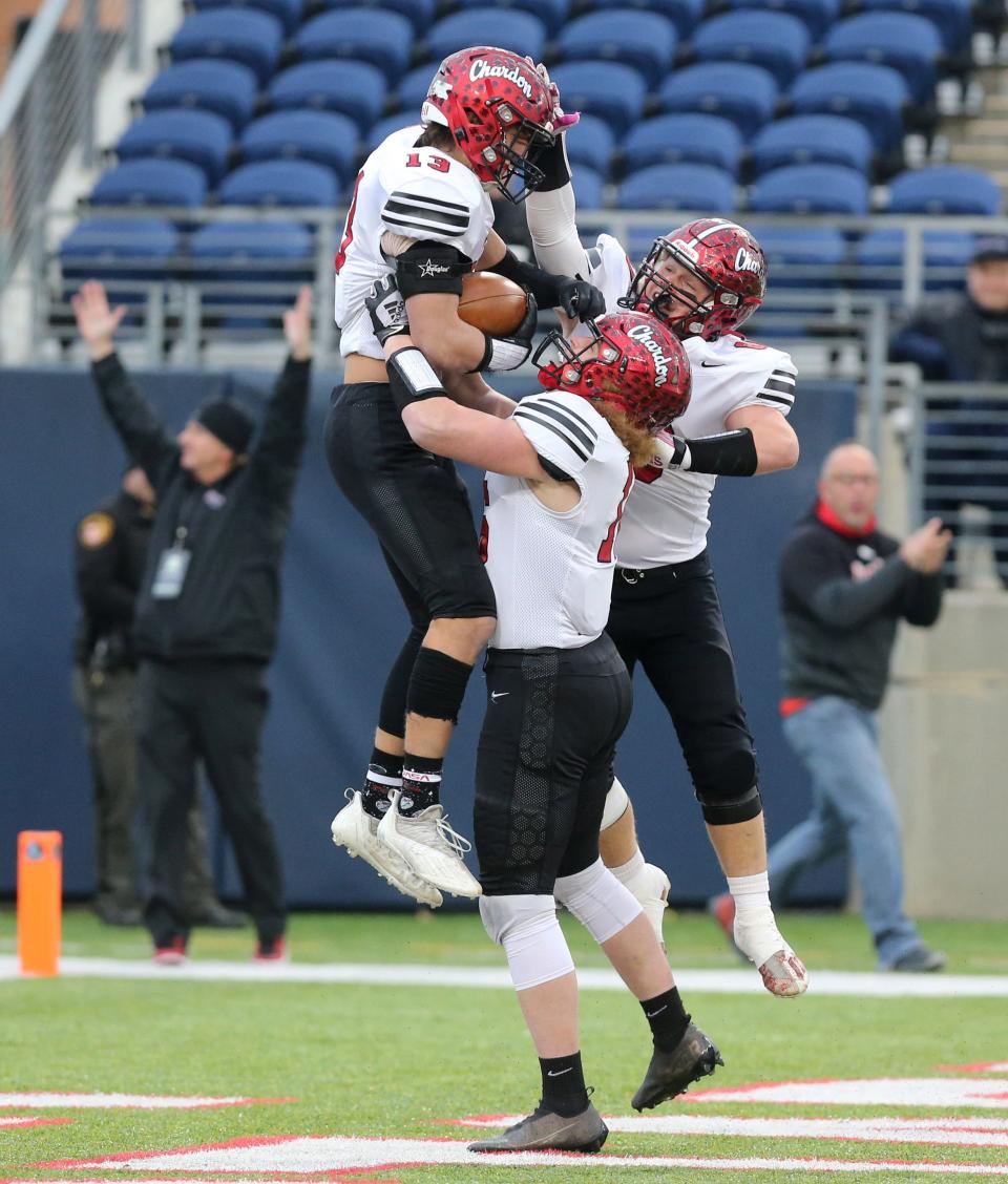 Nathanael Sulka, left, of Chardon celebrates his touchdown with Alex McDonald, center, and TJ Altman, right, during their DIII state championsip game against Hamilton Badin at Tom Benson Hall of Fame Stadium on Friday, Dec. 3, 2021.