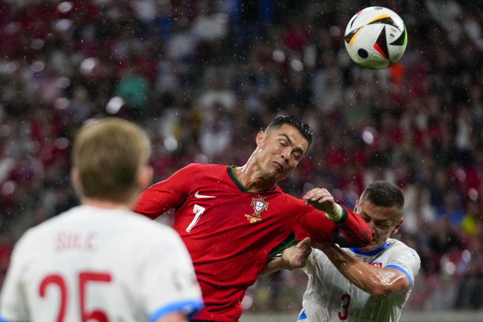 Cristiano Ronaldo se disputa la pelota con un jugador de República Checa este 18 de junio en el primer partido de Portugal en la Eurocopa (AP Photo/Petr Josek)