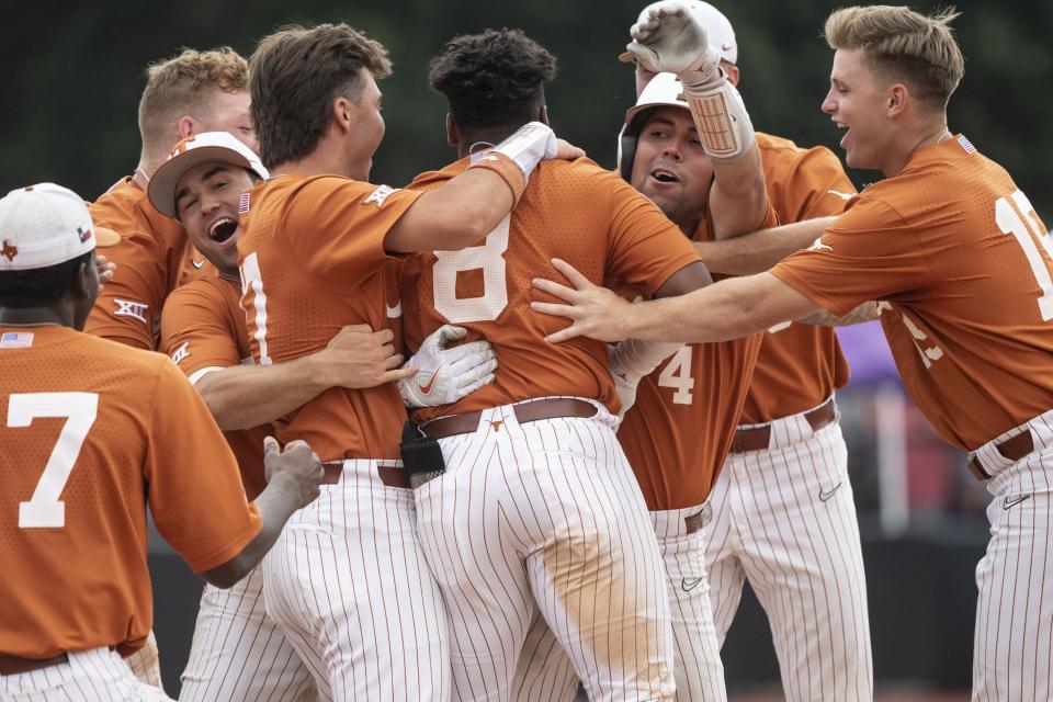Texas' Dylan Campbell, center, is mobbed by teammates after hitting a walk-off single in the ninth inning to give the Longhorns a 9-8 win over East Carolina in Saturday's Game 2 of the Greenville Super Regional. The teams will meet again Sunday for a berth in the College World Series.
