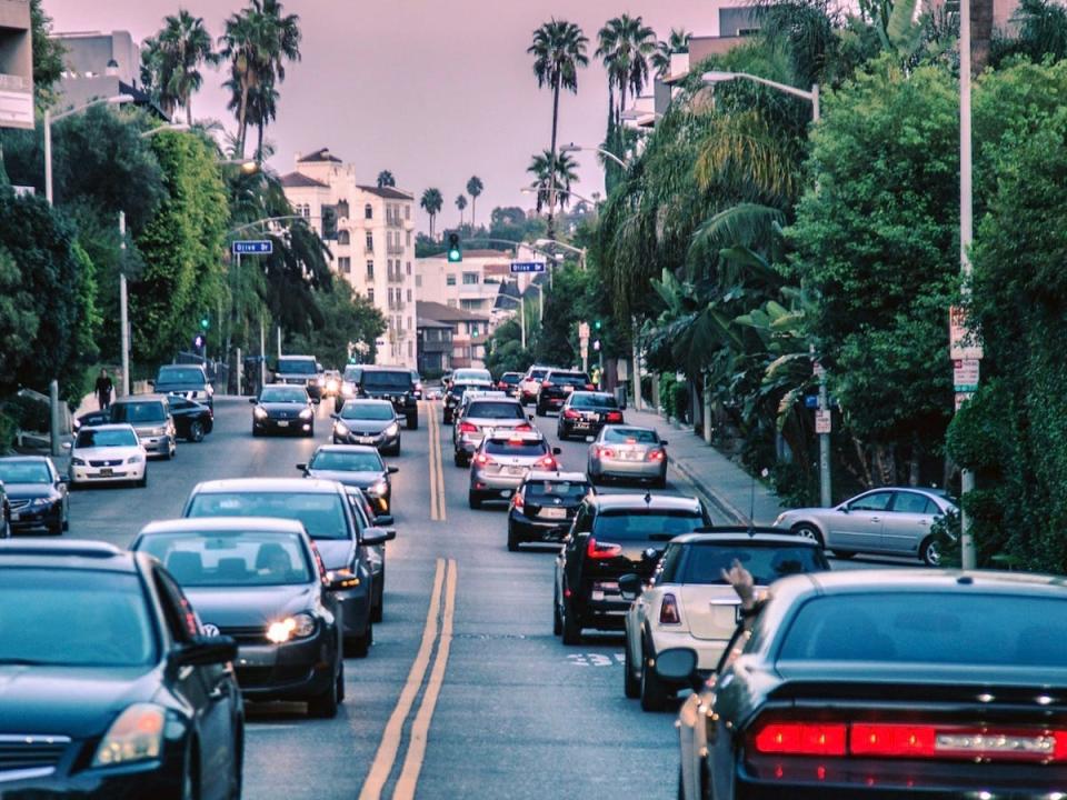 cars driving down an la boulevard at sunset