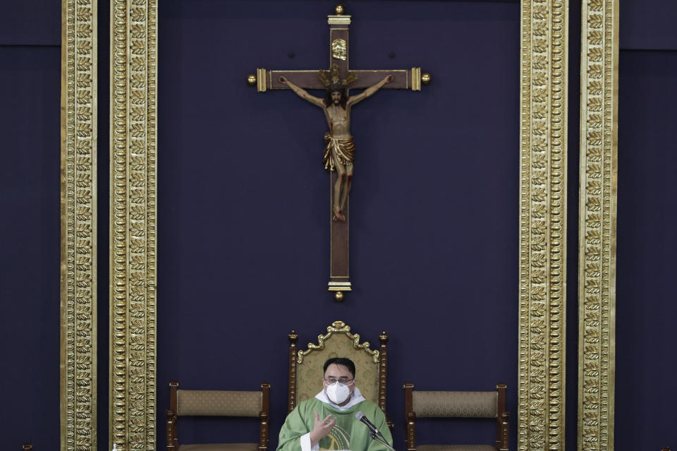 Catholic priest Fr. Ian Espartero gestures as he officiates mass with a few parishioners as a measure to prevent the spread of COVID19 at the Our Lady of Consolation Parish on Sunday, Aug. 2, 2020, in Quezon city, Philippines. Coronavirus infections in the Philippines continues to surge Sunday as medical groups declared the country was waging a losing battle against the contagion and asked the president to reimpose a lockdown in the capital. (AP Photo/Aaron Favila)