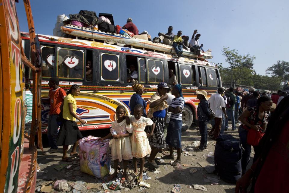 Haitians wait to board buses leaving Port-au-Prince.