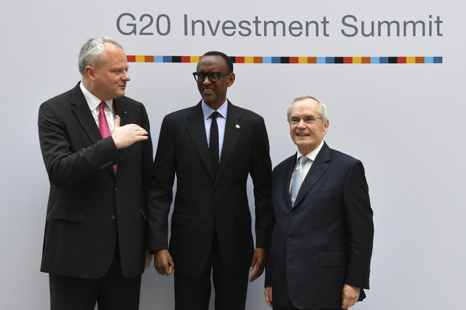 FILE- Stefan Liebing, left, chairman of the German African Business Association (Afrika-Verein der deutschen Wirtschaft), and Heinz-Walter Grosse, right, chairman of the Sub-Saharan Africa Initiative of German Business (SAFRI), pose with Rwanda's President Paul Kagame, center, as he arrives to attend the "G20 Investment Summit - German Business and the CwA Countries 2019" on the sidelines of a Compact with Africa (CwA) in Berlin on November 19, 2019. The G20 group of the world's leading economies is welcoming the African Union as a permanent member, a powerful acknowledgement of the continent of more than 1.3 billion people as its countries seek a more important role on the global stage. (John MacDougall/Pool via AP, File)
