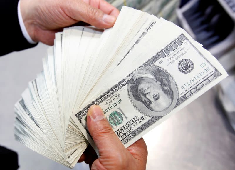 FILE PHOTO: An employee of the Korea Exchange Bank counts one hundred U.S. dollar notes during a photo opportunity at the bank's headquarters in Seoul