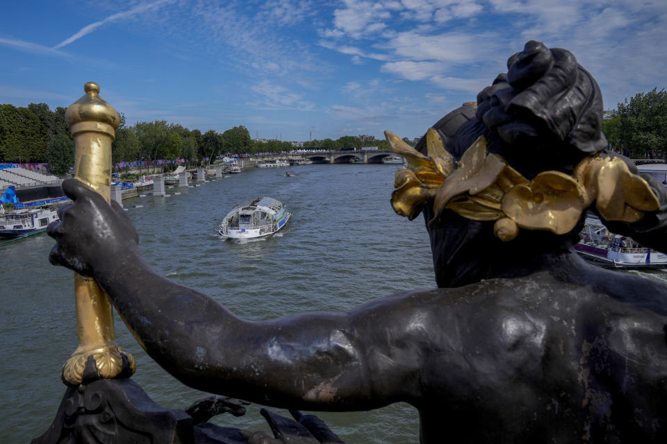 A tourist boat makes its way along the Seine River by the Alexandre III bridge, at the 2024 Summer Olympics, Sunday, July 28, 2024, in Paris, France. (AP Photo/Yasin Dar)