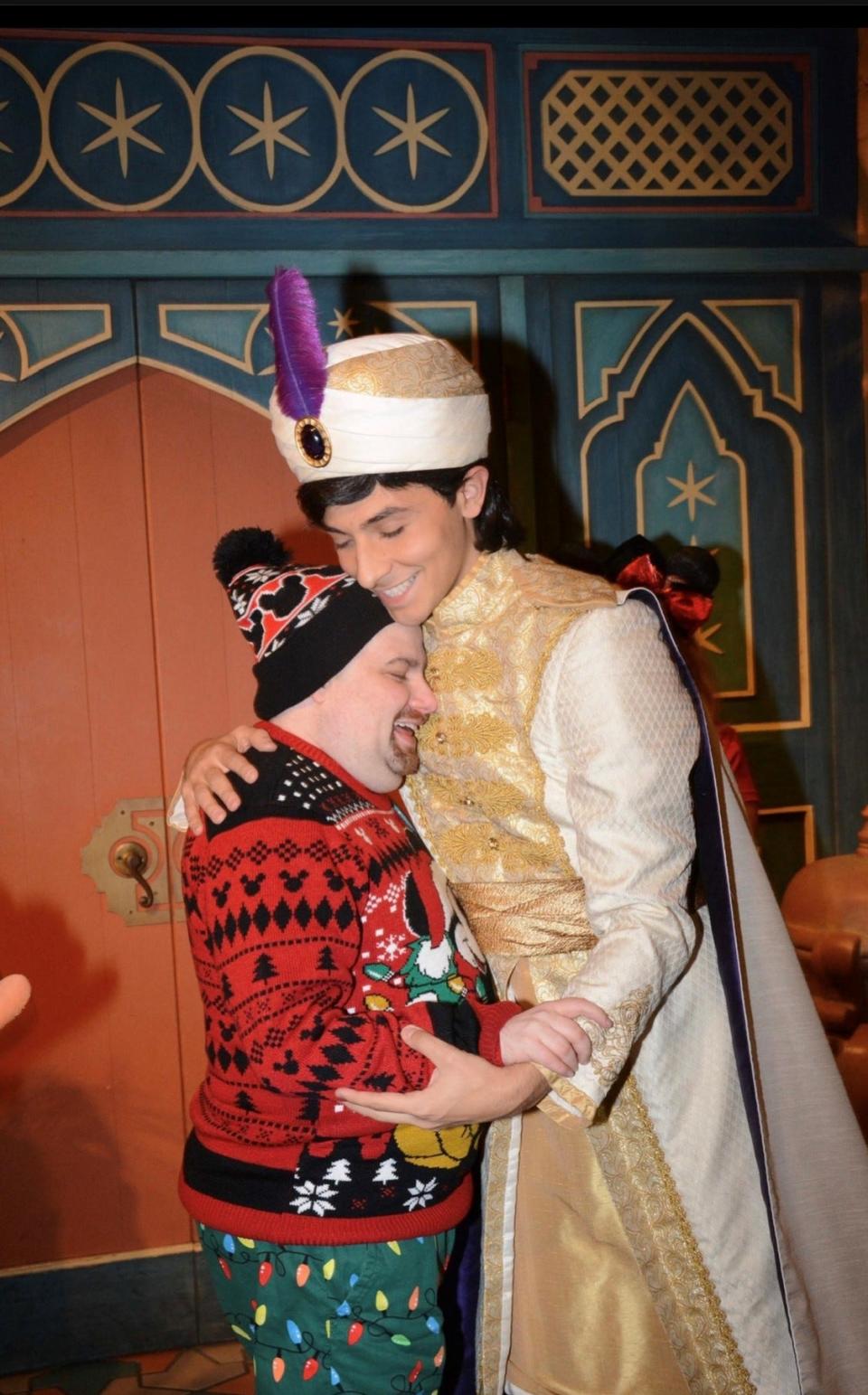 Patrick Hindermyer, left, who has severe and profound disabilities, gets a hug from Aladdin during a pre-pandemic visit to Walt Disney World.