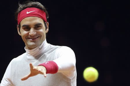 Roger Federer of Switzerland reacts as he returns the ball during a Davis Cup tennis training session at the Pierre Mauroy stadium in Villeneuve d'Ascq, northern France, November 19, 2014. REUTERS/Pascal Rossignol