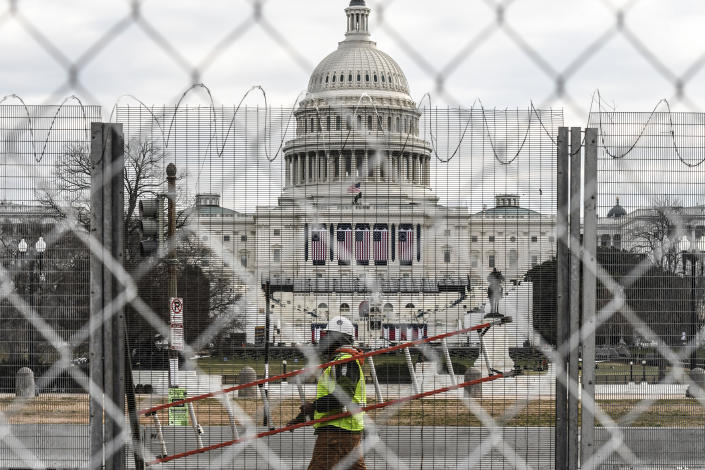 A worker carries a ladder past the Capitol building on the National Mall on January 19, 2021 in Washington, DC. Tight security measures are in place for Inauguration Day due to greater security threats after the attack on the U.S. Capitol on January 6. (Stephanie Keith/Getty Images)