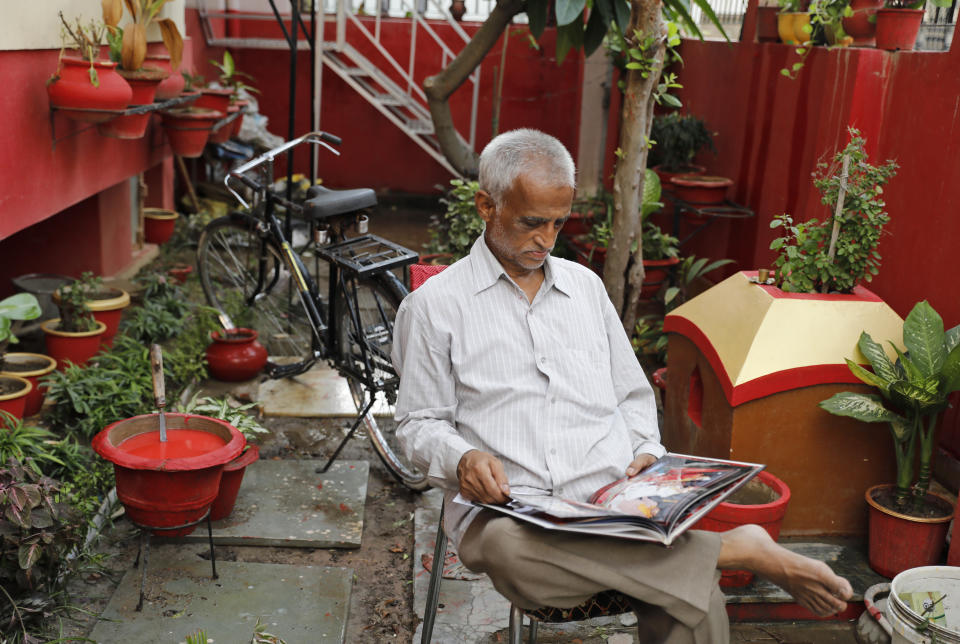 Radha Gobindo Pramanik looks through a family album while sitting in his yard in Lucknow, India, Thursday, June 3, 2021. Pramanisk's wife, his daughter and his unborn grandchild succumbed to the coronavirus along with tens of thousands of others as it ravaged the country in April and May. As India emerges from its darkest days of the pandemic, families across the country are grieving all that they’ve lost and are left wondering if more could have been done to avoid this tragedy. (AP Photo/Rajesh Kumar Singh)