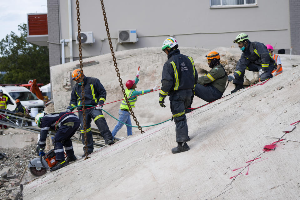 Rescue workers search the site of a building collapse in George, South Africa, Wednesday, May 8, 2024. Rescue teams are searching for dozens of construction workers missing after a multi-story apartment complex collapsed in the coastal city have brought out more survivors as the operation entered a second night of desperate work to find anyone alive in the mangled wreckage. (AP Photo/Jerome Delay)