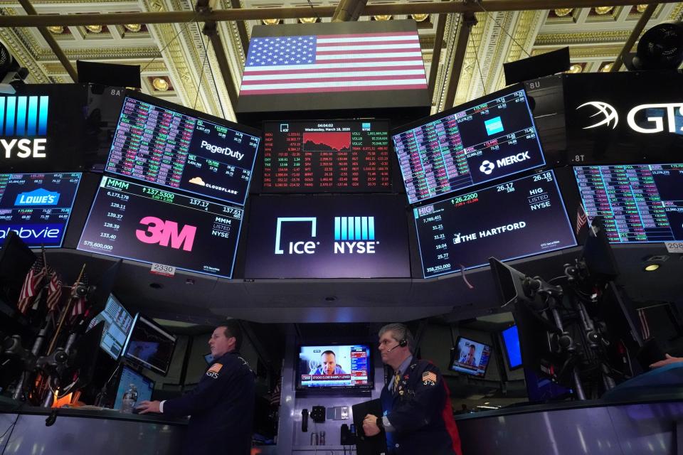 Traders work on the floor at the closing bell of the Dow Industrial Average at the New York Stock Exchange on March 18, 2020 in New York. - Wall Street stocks plunged again March 18, 2020 as the economic toll from the coronavirus mounts and economists warn of a deep recession. The Dow Jones Industrial Average tumbled 6.3 percent, or more than 1,300 points, to close the day at 19,903.50. The index sank by as much as 10 percent earlier in the session, which saw trading halted yet again. (Photo by Bryan R. Smith / AFP) (Photo by BRYAN R. SMITH/AFP via Getty Images)