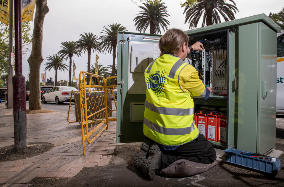 An NBN Co. technician handles hardware in a fiber distribution cabinet during the installation of fiber-to-the-building connections in Sydney. Image: Getty