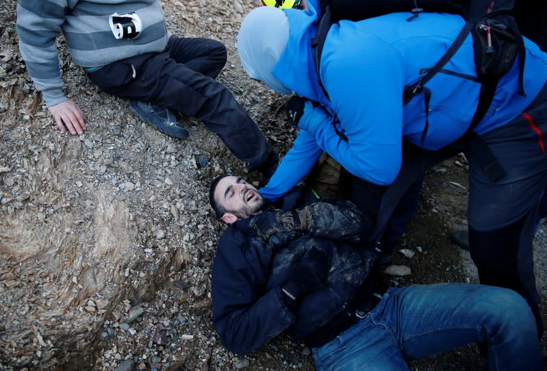 A man lies on the ground as members of Catalan protest group Democratic Tsunami clash with French police officers at the AP-7 highway