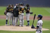 Milwaukee Brewers' Christian Yelich waits to hit while Pittsburgh Pirates players have a meeting on the mound during the second inning of a baseball game Saturday, Aug. 29, 2020, in Milwaukee. (AP Photo/Morry Gash)
