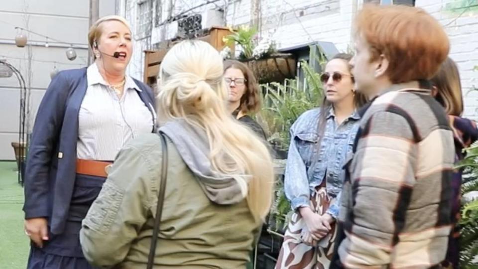 Owner and tour guide of the Bites of the Bluegrass tours, Erin Goins, gives participants a break down of speak easy history at The Grove in Lexington, Ky, during a walking food and history tour of downtown Lexington, Ky, on Thursday, March 21, 2024.