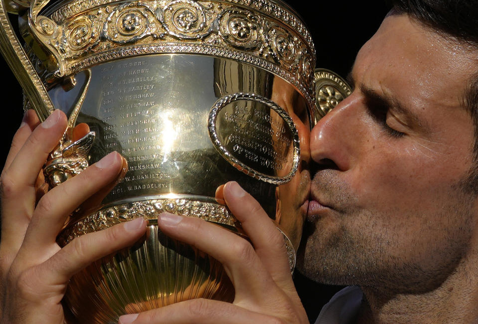 FILE - Serbia's Novak Djokovic kisses the trophy as he celebrates after beating Australia's Nick Kyrgios to win the final of the men's singles on day fourteen of the Wimbledon tennis championships in London, Sunday, July 10, 2022. Djokovic's bid for Wimbledon title No. 8 and Grand Slam trophy No. 24 starts next week. (AP Photo/Kirsty Wigglesworth, File)