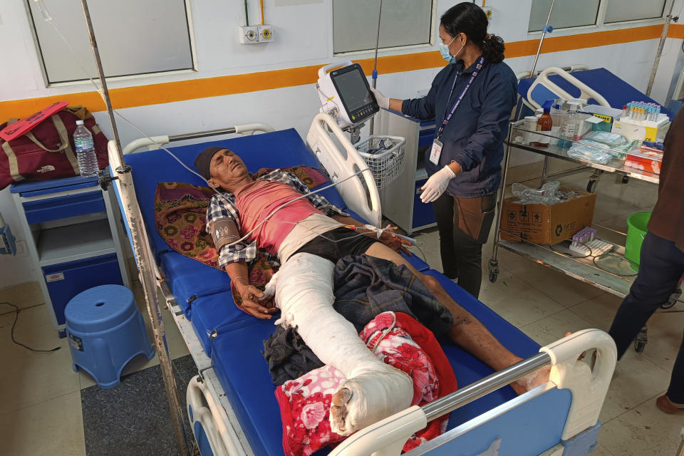 A doctor looks after a patient injured in an earthquake, evacuated from his village and brought to a hospital in Nepalgunj, Nepal, Saturday, Nov. 4, 2023. Helicopters and ground troops rushed to help people hurt in a strong earthquake that shook northwestern Nepal districts just before midnight Friday, killing more than hundred people and injuring dozens more, officials said Saturday. (AP Photo/Krishna Adikari)